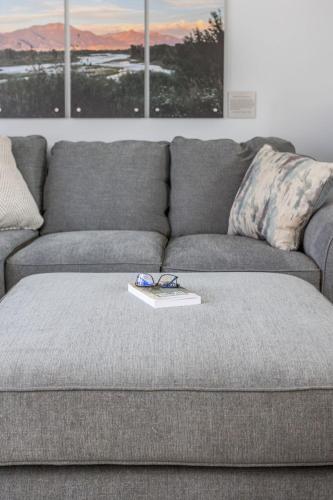 a grey couch with a tray on top of it at Hometown Hideaway - 4br25ba, Pool, Game Room in Greenwood