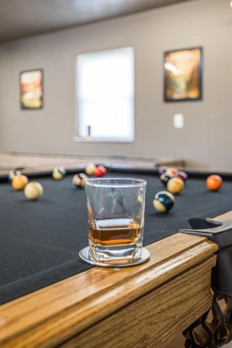 a glass of alcohol sitting on top of a pool table at Hometown Hideaway - 4br25ba, Pool, Game Room in Greenwood