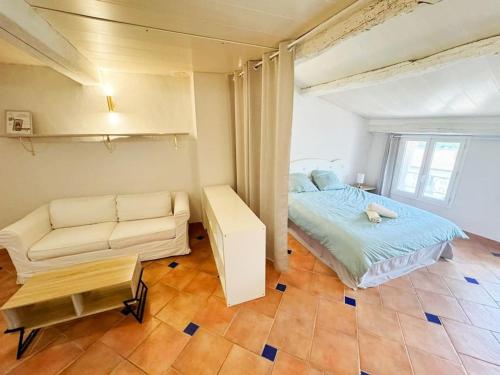 une chambre avec un lit, un canapé et une table dans l'établissement Angelina, cœur du village, calme, proches restaurants et supermarché, à Bargemon