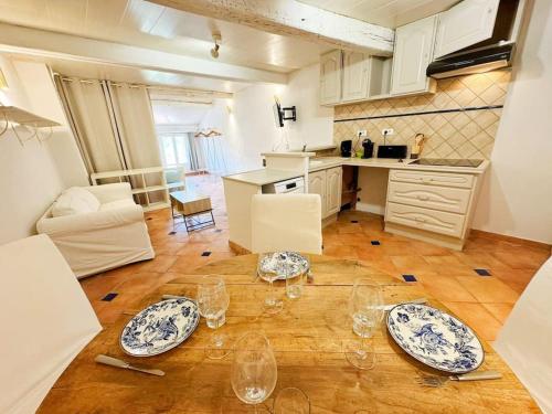 - une cuisine avec des assiettes et des verres à vin sur une table dans l'établissement Angelina, cœur du village, calme, proches restaurants et supermarché, à Bargemon