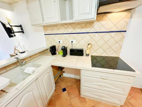 une cuisine avec des armoires blanches et un comptoir dans l'établissement Angelina, cœur du village, calme, proches restaurants et supermarché, à Bargemon
