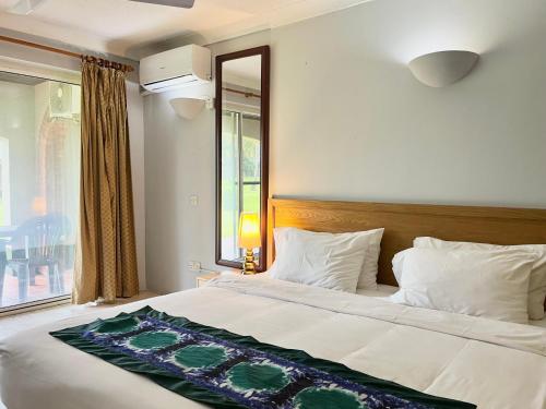 a bedroom with a large bed with a large window at Kololi Beach Resort in Kololi