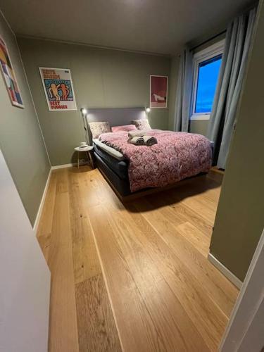 a bedroom with a bed and a wooden floor at Hus i Harstad in Harstad