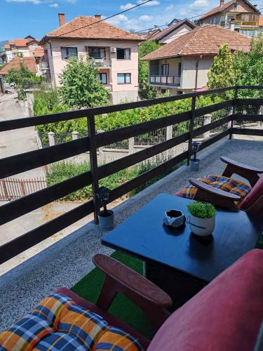 a patio with a table and chairs on a balcony at El&Ma Apartment - 3 bedroom apartment with balcony close to Sarajevo City Center, Sunnyland - free parking in Sarajevo