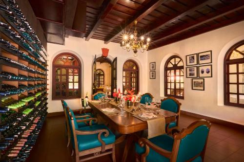 a dining room with a table and chairs and wine bottles at Taj Kumarakom Resort and Spa Kerala in Kumarakom