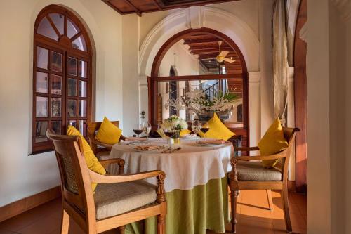 a dining room with a table with yellow pillows at Taj Kumarakom Resort and Spa Kerala in Kumarakom