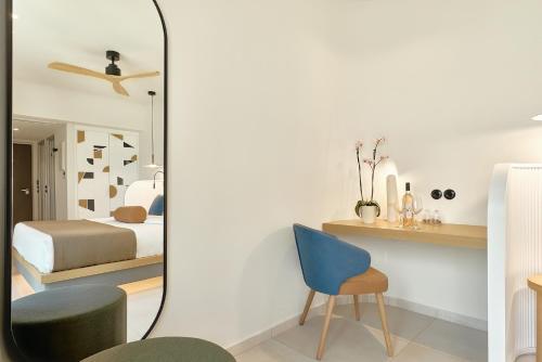 a bedroom with a bed and a blue chair at Paralos Kosta Alímia in Hersonissos