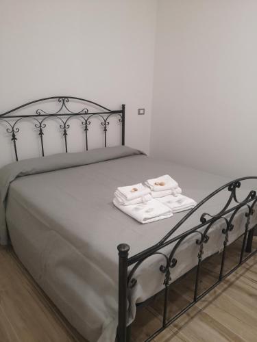 a bed with two white towels sitting on it at Terracina Holiday Succursale in Terracina