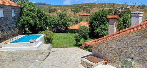 a house with a swimming pool in a yard at Casa da Rosa Porreiras in Paredes de Coura