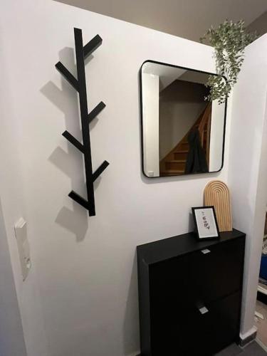 a mirror on a wall next to a black dresser at Fischer-Chic - Die Bude Maasholm in Maasholm