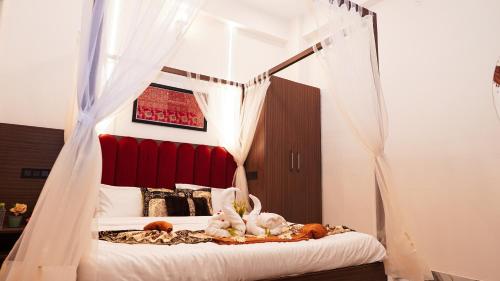 Dos animales de peluche en una cama en un dormitorio. en Mangalmay kashi Near kashi Vishwanath nd Ganga Ghat, en Varanasi