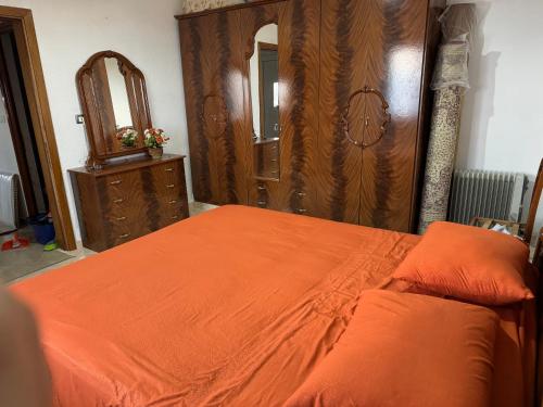 a bedroom with an orange bed and a mirror at Best View Villa in Udënisht