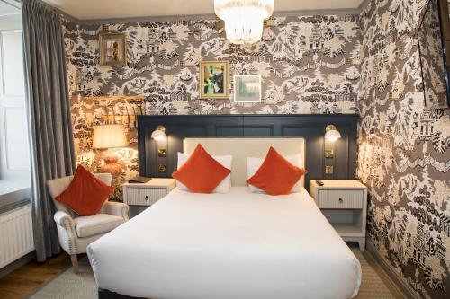 a bedroom with a large white bed with orange pillows at Henrietta House, a member of Radisson Individuals in Bath