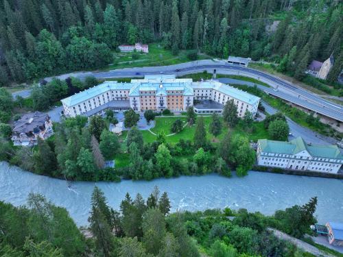 an aerial view of a building next to a river at Scuol Palace - Culture, Nature & Health in Scuol