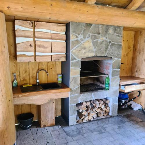 a kitchen with a stone oven in a cabin at Rajski Zakątek - jeden domek na działce z gorącą balią i mini ZOO in Kamionka Wielka