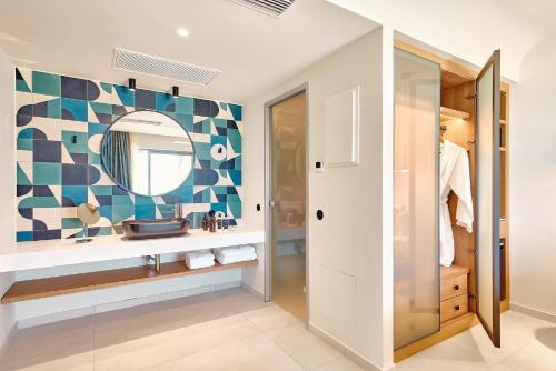 a bathroom with a sink and a mirror at Paralos Kosta Alímia in Hersonissos