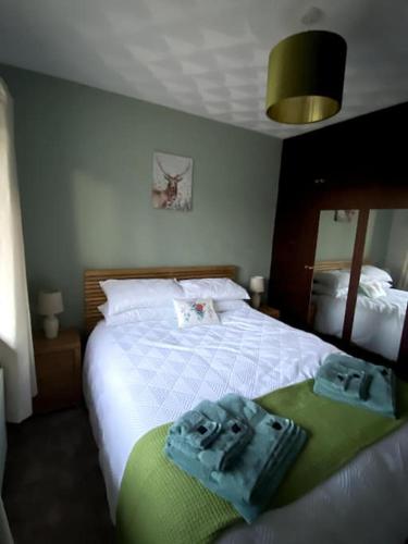a bedroom with a bed with two towels on it at Eileen's Cottage in Castlerock