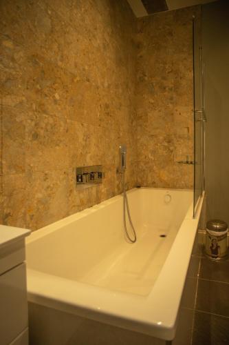 a bathroom with a tub with a phone on the wall at Buccleuch and Queensberry Arms Hotel in Thornhill