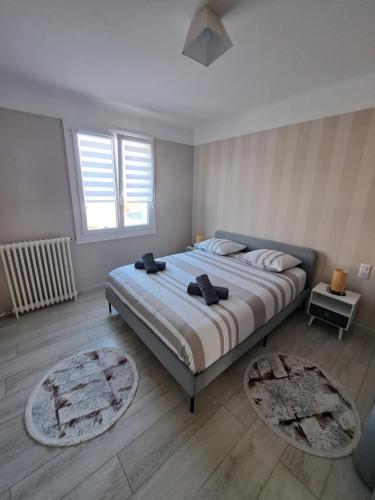 - une chambre avec un grand lit et 2 tapis dans l'établissement Maison de ville avec cour et terrasse, à Vichy