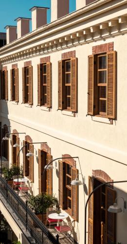 a building with brown shutters and tables on a balcony at Ecole St. Pierre Hotel in Istanbul