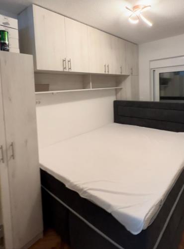 a bed in a room with white cabinets at Apartman Meljine, Opština Herceg Novi in Meljine