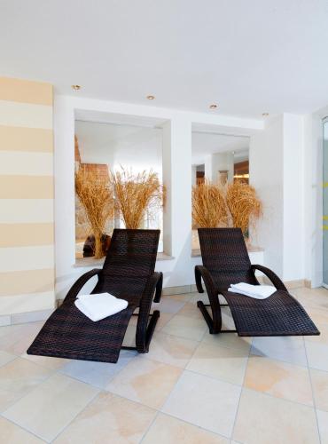 two chairs in a room with two mirrors at Kneipp-Kurhotel Steinle in Bad Wörishofen