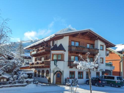 a large building with snow on the ground at Café Pension Heim in Kirchberg in Tirol