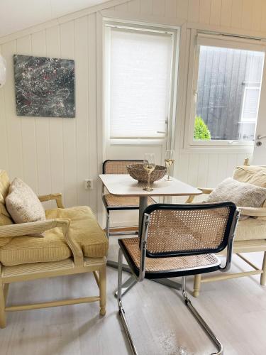 a living room with chairs and a table and a couch at Brightside Apartment in Kristiansand