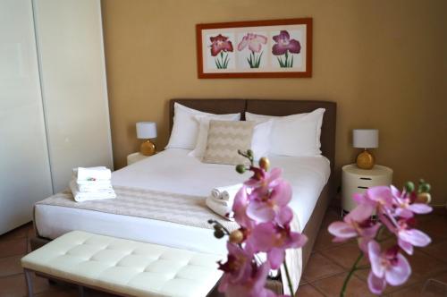 a bedroom with a bed with white sheets and purple flowers at Loger Confort Residence & Apartments in Turin