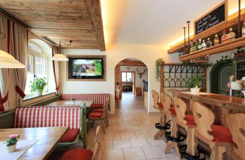 a restaurant with tables and chairs and a bar at Café Pension Heim in Kirchberg in Tirol