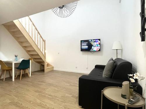 a living room with a couch and a tv on the wall at 731 Joli studio mezzanine proche du métro L9 in Bagnolet