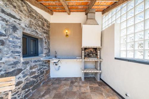 a room with a stone wall and a sink at SUPER Camacha - Casa da Eira in Camacha