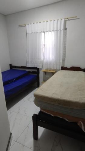 Un dormitorio con dos camas y una ventana. en Casa recém construída na Ilha Comprida, en Ilha Comprida