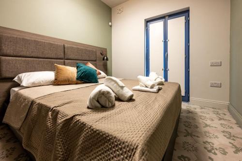 a bedroom with a large bed with pillows on it at Casa Rosanna Malta B&B Adults only 16 plus in Marsaskala
