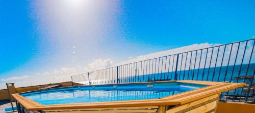 - un balcon avec une grande piscine dans l'établissement Les Voiles Blanches, à Sari-Solenzara