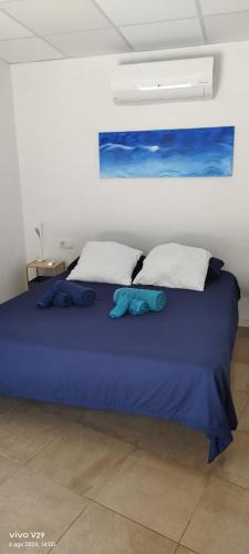 a bedroom with a blue bed with two pillows at La Hispañola in El Campello