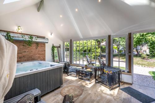 - une grande salle de bains avec une grande baignoire dans une chambre dotée de fenêtres dans l'établissement La Maison du Corsaire, à Honfleur