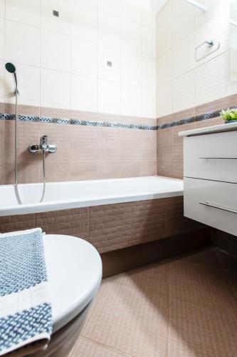 a bathroom with a tub and a toilet and a sink at Lis153 by Smart Cozy Suites - Top Floors with Amazing City View - Available 24hr in Athens
