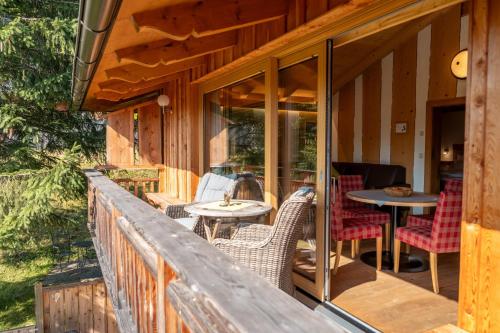 a porch of a cabin with chairs and tables at Bayern Chalets bei Salzburg und Berchtesgaden mit Whirlpool und Sauna in Ainring