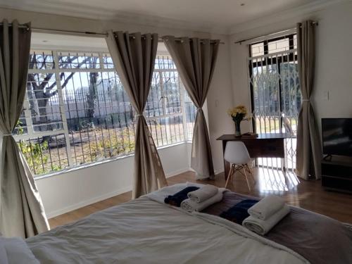 a bedroom with a bed with two pillows on it at Paulshof Guesthouse - Kingsway B&B in Sandton