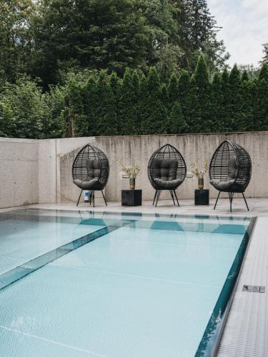 two chairs sitting next to a swimming pool at VAYA Zillertal inklusive Gästekarte Erste Ferienregion Zillertal in Aschau