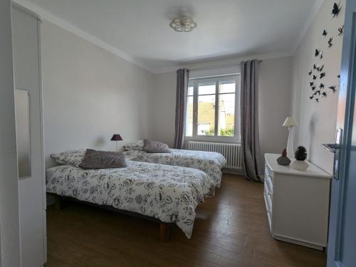 een slaapkamer met twee bedden en een raam bij Villa Gisèle in Le Touquet-Paris-Plage