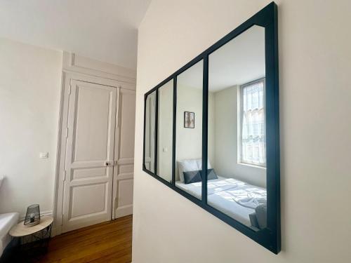un miroir accroché au mur dans une pièce dans l'établissement Le Thémis, cosy et élégant, à Limoges