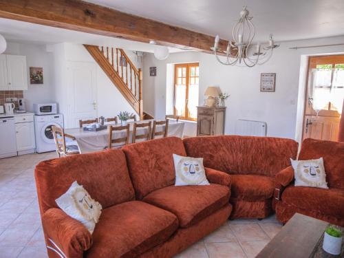 un salon avec un canapé rouge et une cuisine dans l'établissement Les Terrasses Des Rossignols, à Chémery