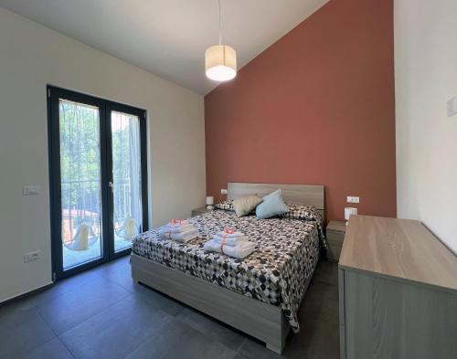 a bedroom with a bed and a large window at Tenuta Grezzosa in Vibonati