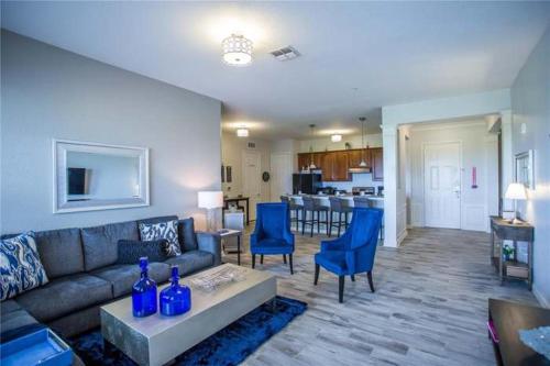 a living room with a couch and blue chairs at The Epic Boca Penthouse Vista Cay Orlando in Orlando