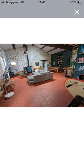 un salon avec un canapé et un mur de briques dans l'établissement Maison de campagne avec piscine, à Mauguio