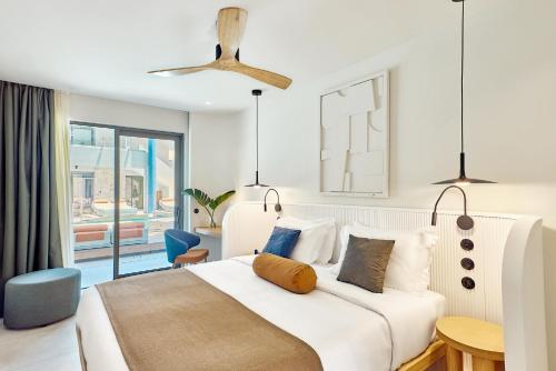 a bedroom with a large white bed and a balcony at Paralos Kosta Alímia in Hersonissos