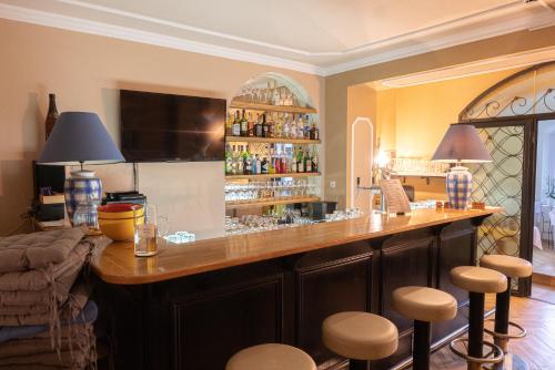 a bar in a room with stools around it at Hotel Lindenhof in Bad Gastein