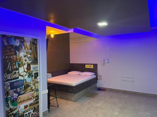 a room with a bed with a purple wall at Motel Drive in T - Prolongamento da Avenida Getúlio Vargas fácil acesso ao Shopping Pátio Chapecó in Chapecó
